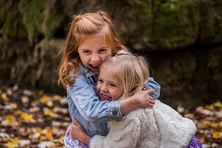 Two young girls hugging and smiling.