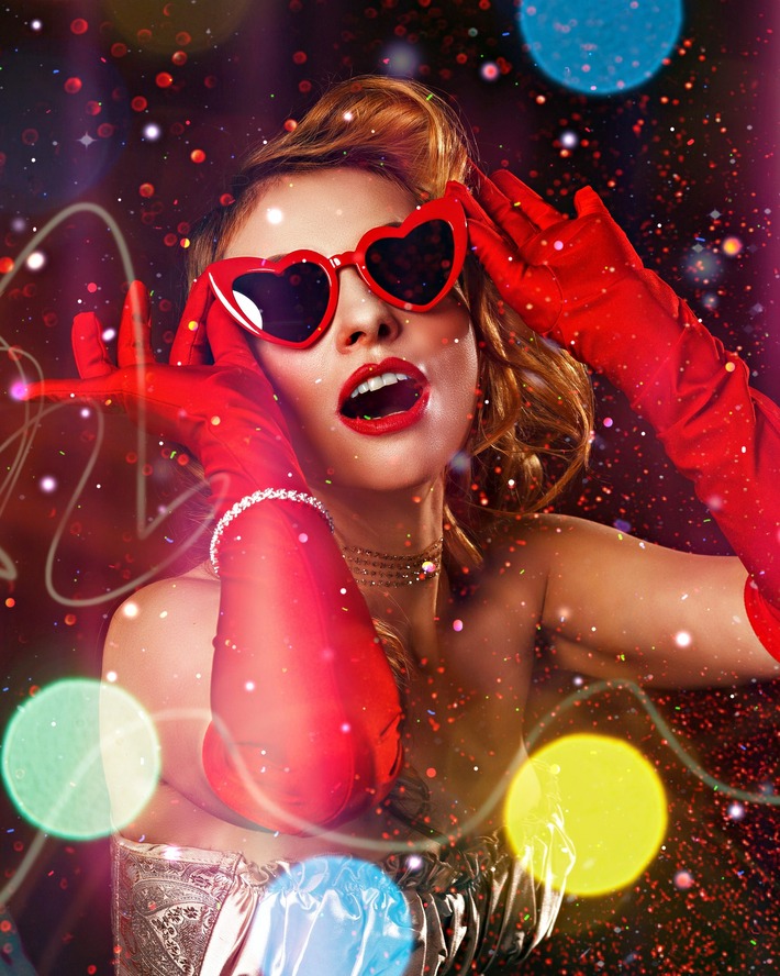 Woman in red heart sunglasses and red gloves with sparkles all around her like she's putting on a show.